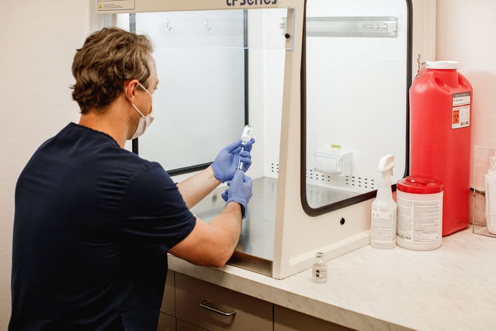 Dr. Borys preparing an injection under a laminar flow hood using sterile technique