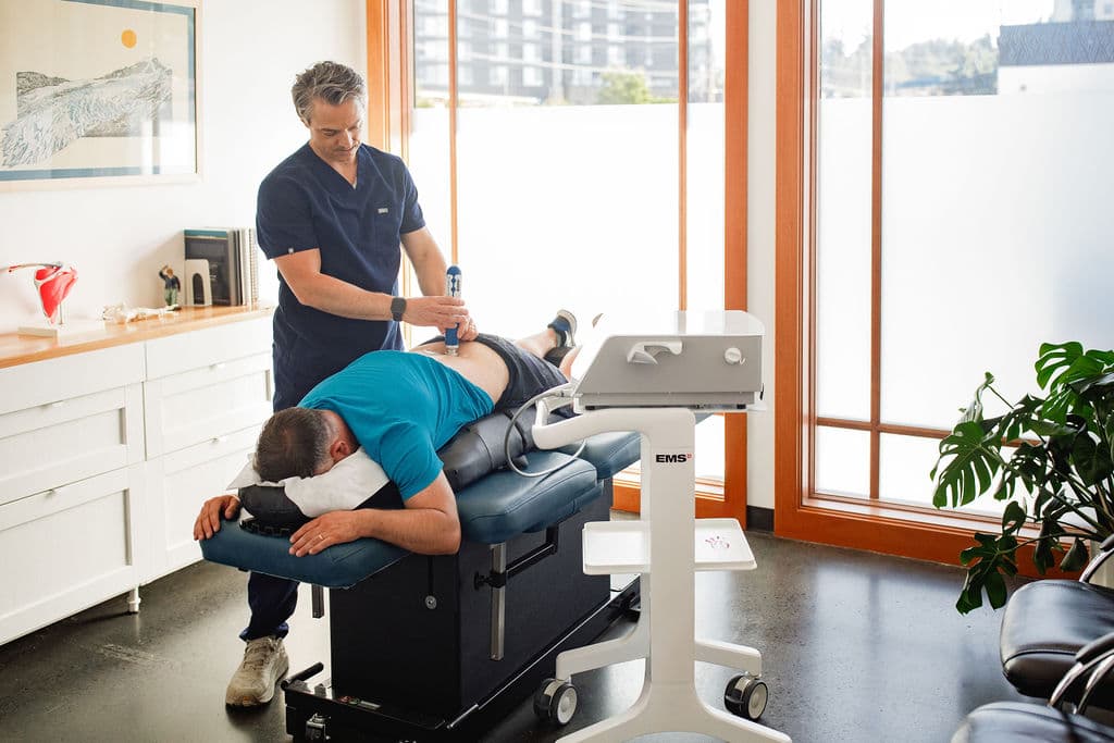 Dr. Borys administering shockwave therapy to a patient using the EMS Dolorclast Radial device