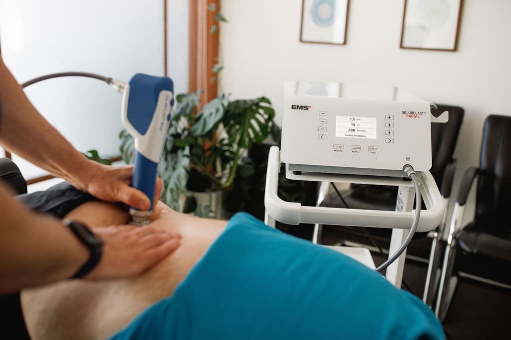 EMS Dolorclast Radial device display showing treatment parameters: 1.9 Bar, 15 Hz, 880 impulses