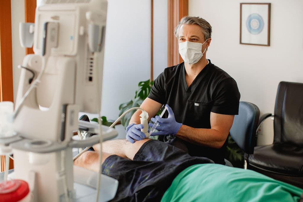 Dr. Borys performing an ultrasound-guided injection on a patient's knee